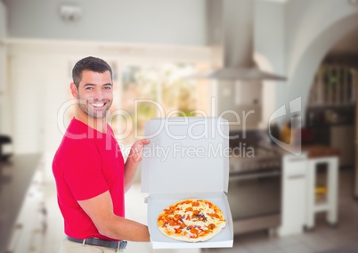 Happy deliveryman showing the pizza in the restaurant kitchen
