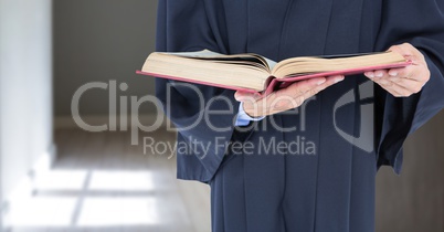 Judge holding book in front of corridor