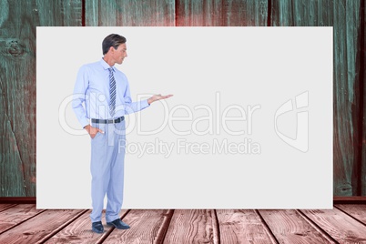 Businessman gesturing while standing against blank billboard