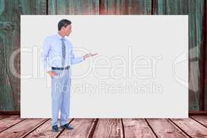 Businessman gesturing while standing against blank billboard