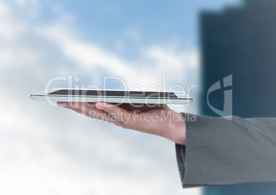 Hand with tablet against blurry building
