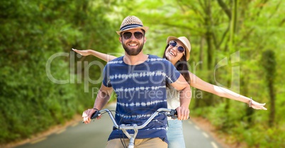 Happy couple riding bicycle on street