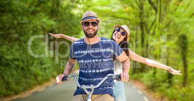 Happy couple riding bicycle on street