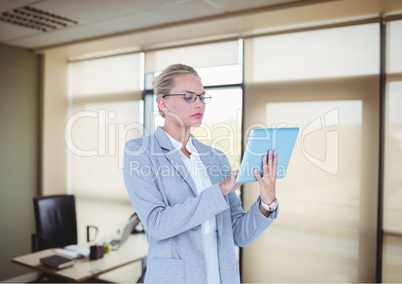 Serious business woman with tablet in the office