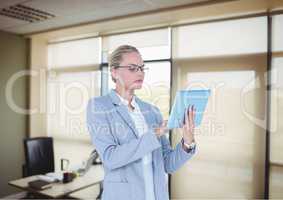 Serious business woman with tablet in the office