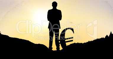 Silhouette businessman with euro sign on field during sunset