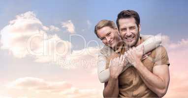 Portrait of smiling couple embracing against cloudy sky