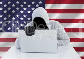 Anonymous Criminal in hood with laptop in front of American flag