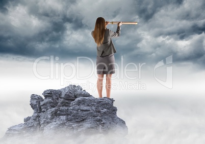 Business woman with telescope on mountain peak against storm clouds