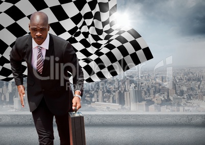 Business man running with briefcase against skyline with sun and checkered flag