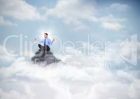 Business man with flare meditating on mountain peak in the clouds
