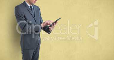 Midsection of businessman using digital tablet over colored background