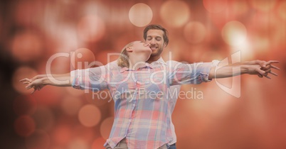 Loving couple with arms outstretched over blur background