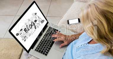 High angle view of woman using laptop with blog text on screen while sitting on sofa