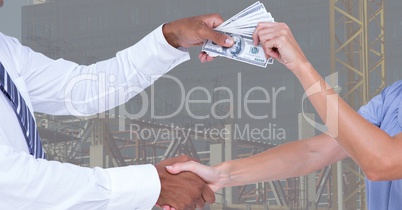 Business people shaking hands while passing money representing corruption concept