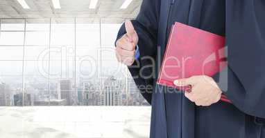 Judge holding book in front of office windows over city