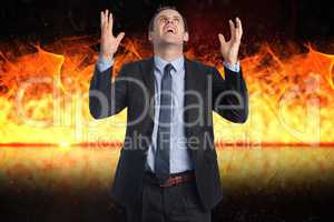 Digital composite image of angry businessman with fire in background