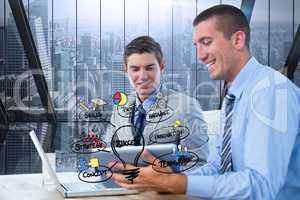 Digital composite image of businessmen using laptop by icons in office