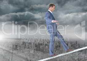 Walking businessman on tightrope over city and clouds