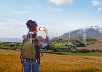 mountain travel,red hair woman with hay, taking a photo with her phone