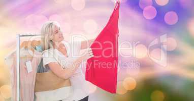 Smiling woman looking at new dress over bokeh