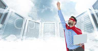Business man superhero with laptop and hand in air against servers and clouds with white interface