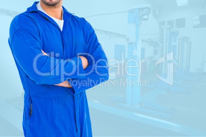 Midsection of worker with arms crossed standing in workshop
