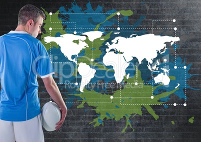 Rugby player holding ball next to Colorful Map with paint splatters on wall background