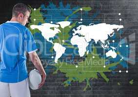 Rugby player holding ball next to Colorful Map with paint splatters on wall background