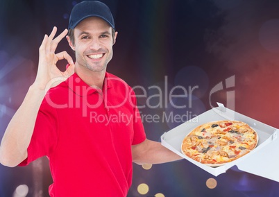 Happy delivery man sawing the pizza. Lights background