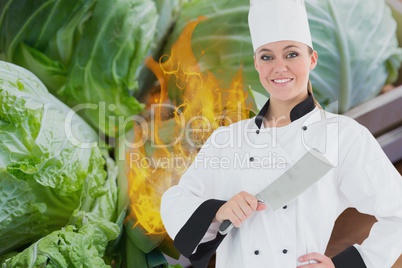 Portrait of chef holding kitchen knife with fire and vegetables in background