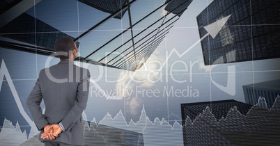 Digital composite image of businessman looking at graphs and buildings