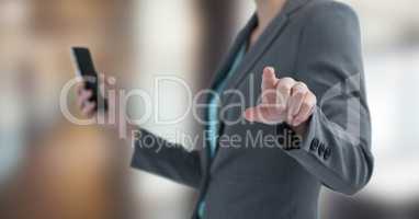 Midsection of businesswoman pointing while holding mobile phone