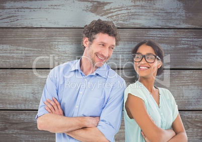Business people with arms crossed against wooden wall