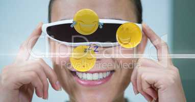 Happy woman looking at various emojis on VR glasses