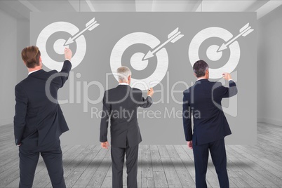 Digital composite image of business people drawing arrow with target symbol