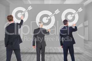 Digital composite image of business people drawing arrow with target symbol