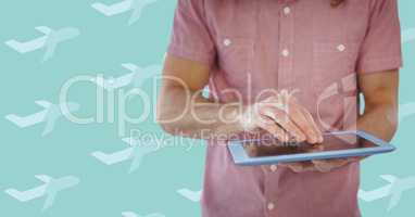 Man pink shirt mid section with tablet against aqua aeroplane pattern