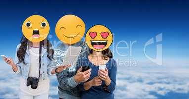 Friends with emojis over faces using technologies in sky