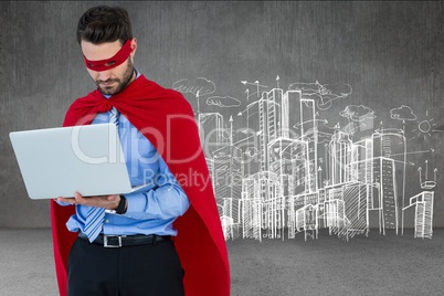 Businessman in super hero costume using laptop