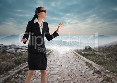 Business woman blindfolded walking down road