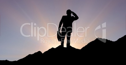 Silhouette businessman standing on mountain against sky during sunset