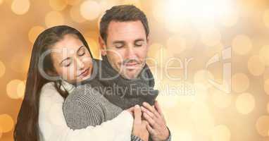 Woman with eyes closed embracing man during winter