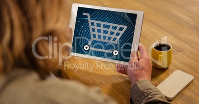 Woman looking at shopping cart icon on tablet PC