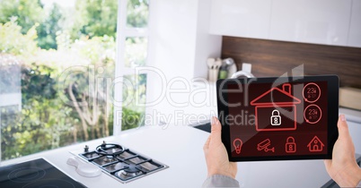 Businessman's hands holding digital tablet with house shape on screen