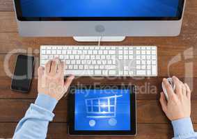Person using Tablet and computer with Shopping trolley icon