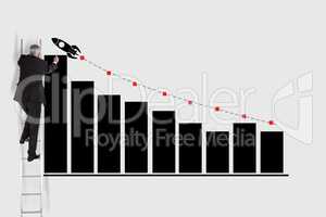 Businessman on ladder drawing graph and rocket on wall