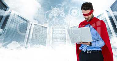 Business man superhero with laptop against servers and clouds with white interface