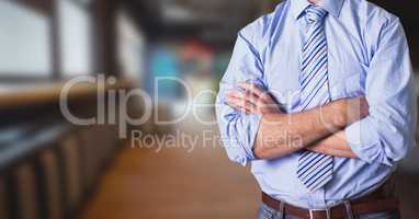 Midsection of businessman with arms crossed standing In office