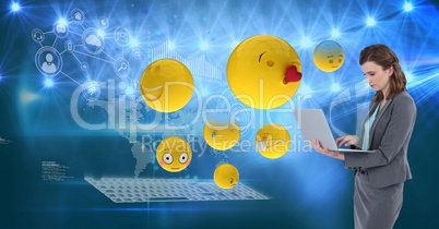 Digital composite image of emojis flying by businesswoman using laptop against tech graphics in back
